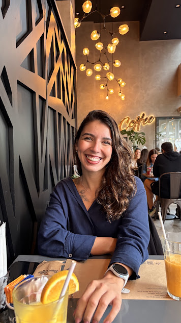 Amanda Lambert sorrindo, sentada em um café